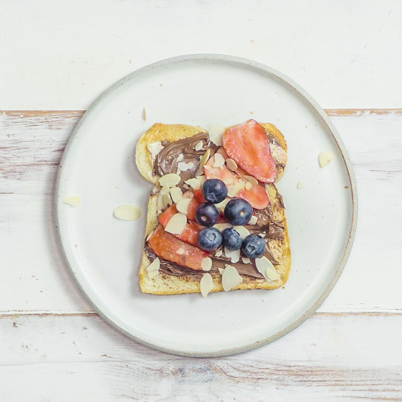 TOAST DELUXE S NUGÁTOVÝM KRÉMEM A ČERSTVÝM OVOCEM, SYPANÝ MANDLOVÝMI VLOČKAMI